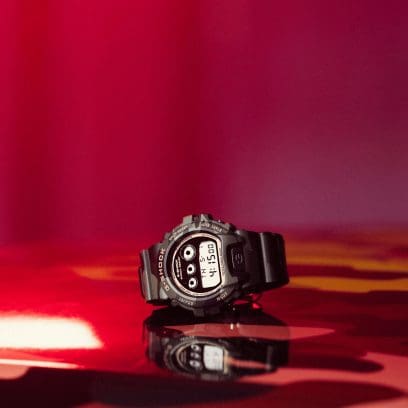 Het polshorloge DW-6900CMG-3ER van G-SHOCK met gouden accenten op de kast en rondom de wijzerplaat