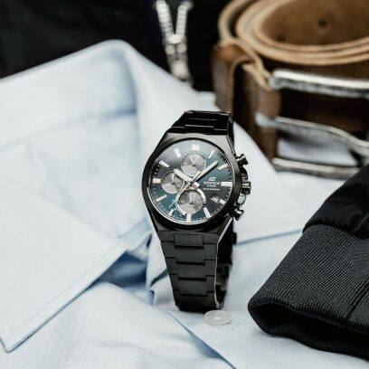 De EFS-S630DC-2AV staat met gesloten polsband op een lichtblauw shirt. Op de achtergrond is een bruine riem te zien.