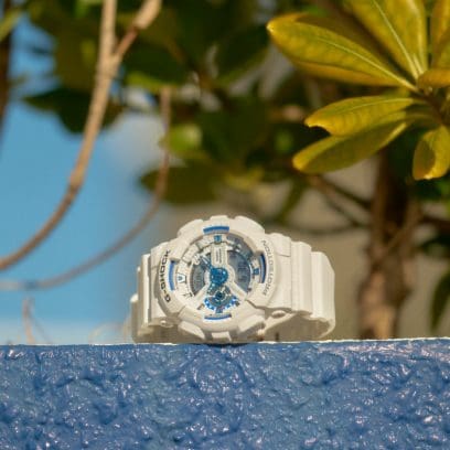 GA-110HDS-7AER ligt op een muur. Op de achtergrond zijn planten en blauwe lucht te zien