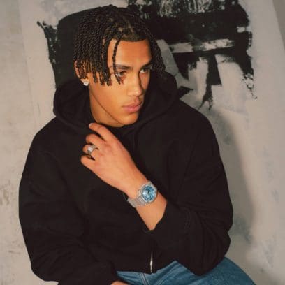 Een man draagt de GA-2100BM-7A2 in combinatie met een zwarte trui om zijn pols tegen een witte achtergrond. 