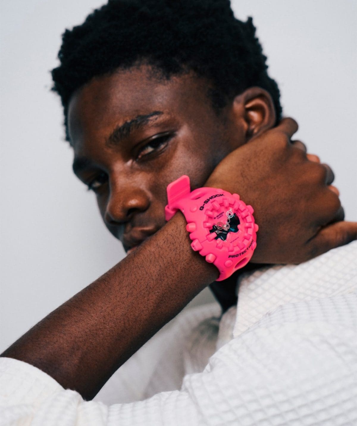 Een man met een donkere huidskleur draagt de roze GA-V01-4AER om zijn pols.