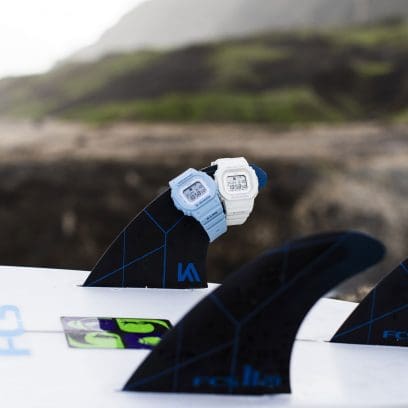 Van links naar rechts: GLX-S5600-2, GLX-S5600-7B horloges van G-SHOCK op de vin van een surfplank