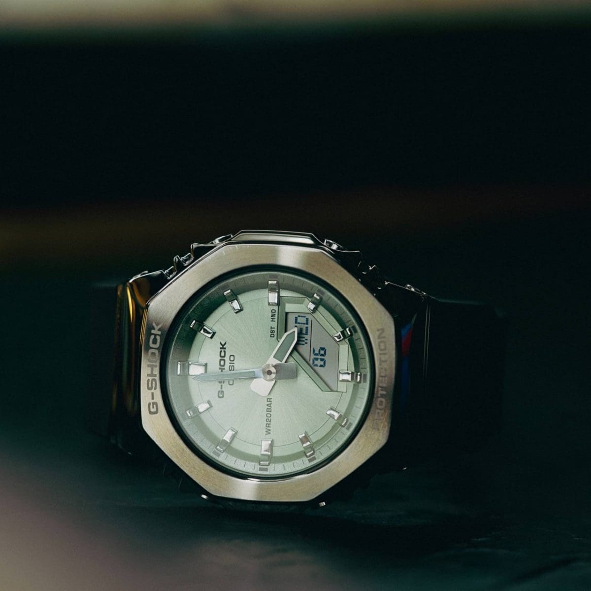 Close-up van de GM-S2110-3A op een donker, licht reflecterend oppervlak tegen een donkere achtergrond.