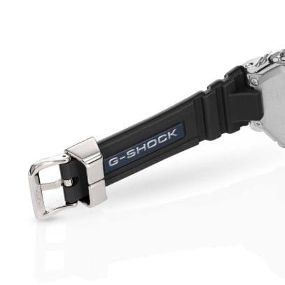 Zwarte siliconen band met zilveren sluiting en schuifknop. Op de achterkant staat het G-SHOCK-logo in zilver.