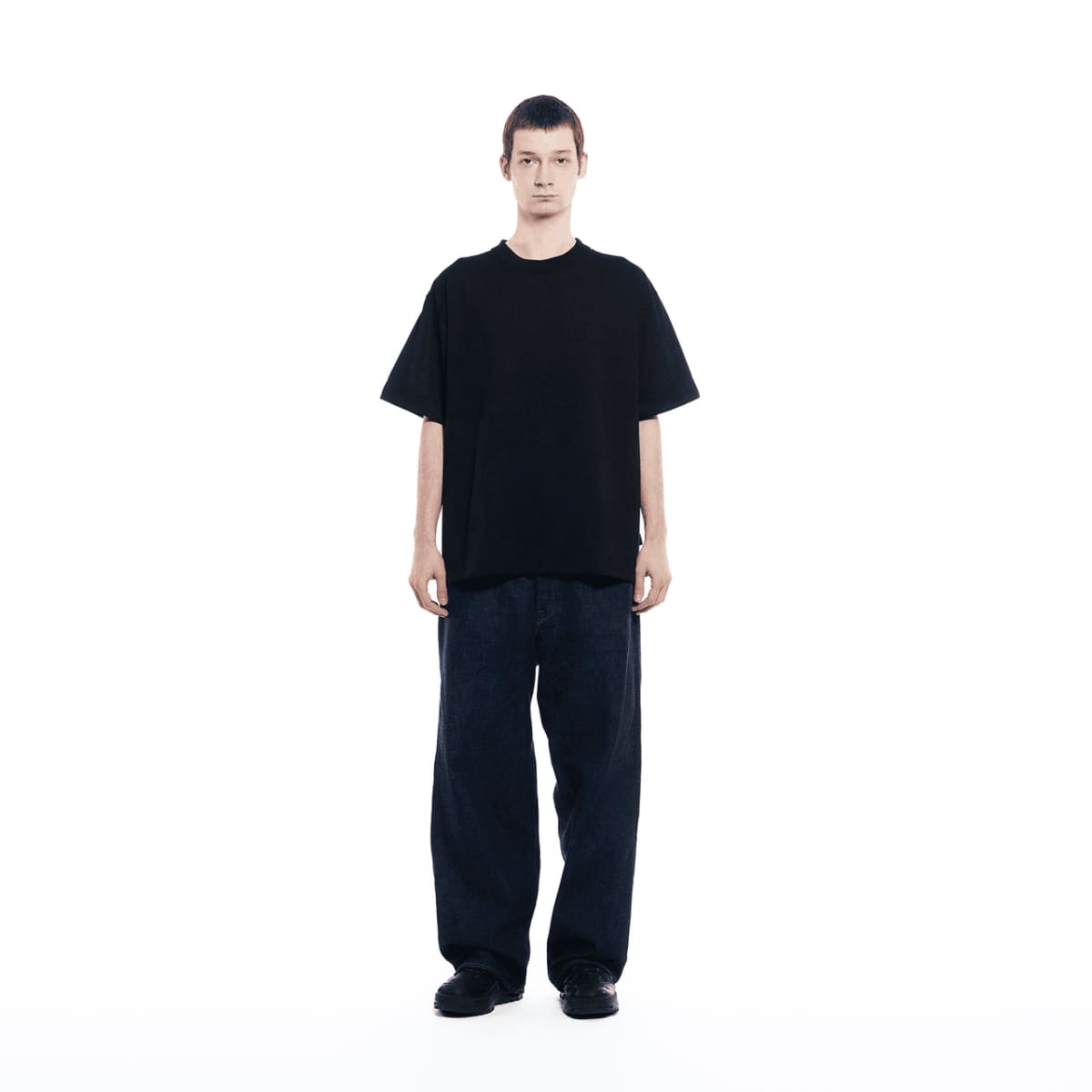 Um homem vestindo calça jeans escura está usando a camiseta da GXFAB.