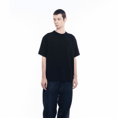 Um homem vestindo calça jeans escura está usando a camiseta da GXFAB.