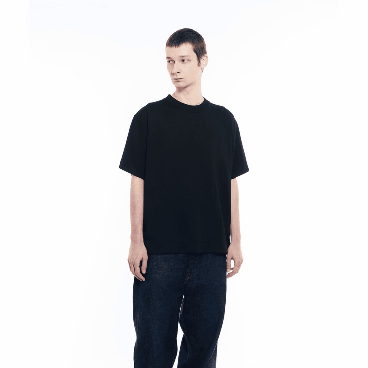 Um homem vestindo calça jeans escura está usando a camiseta da GXFAB.