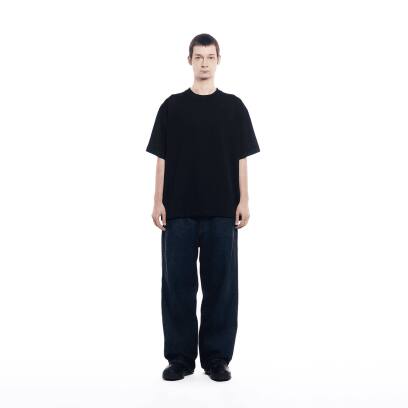 Um homem vestindo calça jeans escura está usando a camiseta da GXFAB.