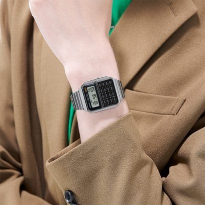 O relógio calculadora CA-500WE-1A no pulso de uma mulher com um blazer castanho claro