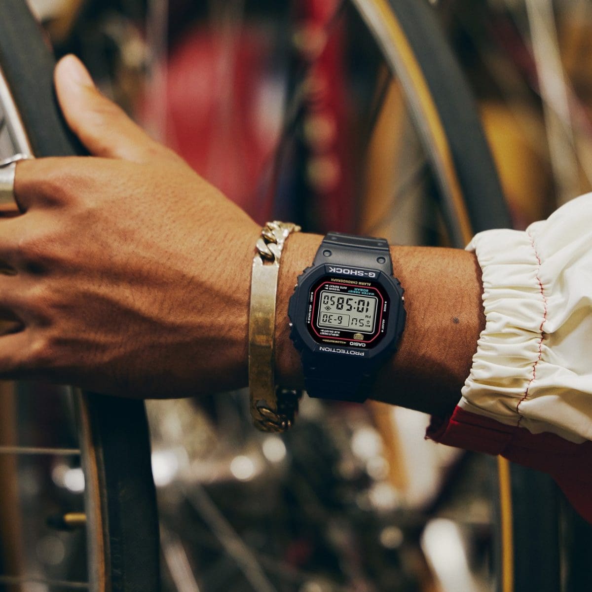 A DW-5600RL-1 no pulso de um homem com uma bracelete prateada adicional
