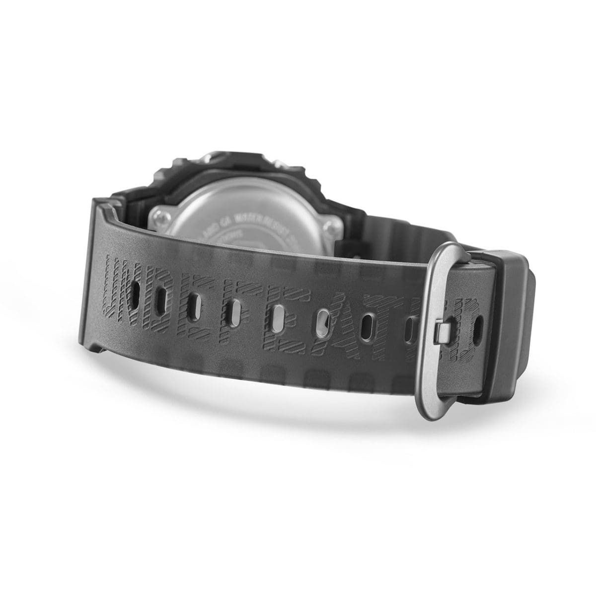 Vista traseira do DWE-5600UD-1ER com a pulseira fechada. A palavra UNDEFEATED está gravada na pulseira preta semitransparente