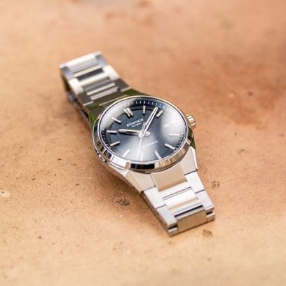 O relógio de pulso mecânico EDIFICE EFK-110D-2A repousa sobre uma superfície de pedra