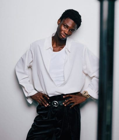 Um homem de pele escura com uma camisola branca usa o GA-V01A-9AER no pulso.