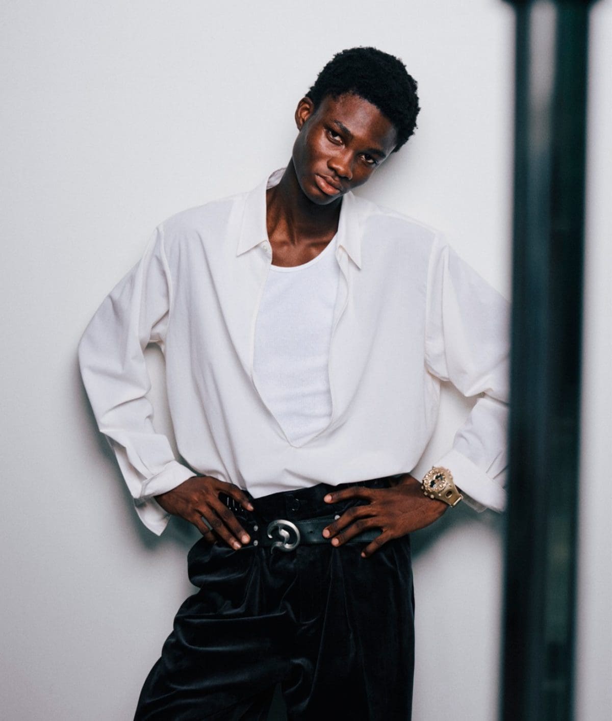 Um homem de pele escura com uma camisola branca usa o GA-V01A-9AER no pulso.