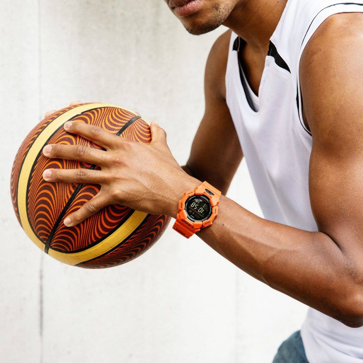 Relógio de pulso G-SHOCK GD-010-4 no pulso de um homem que joga basquetebol