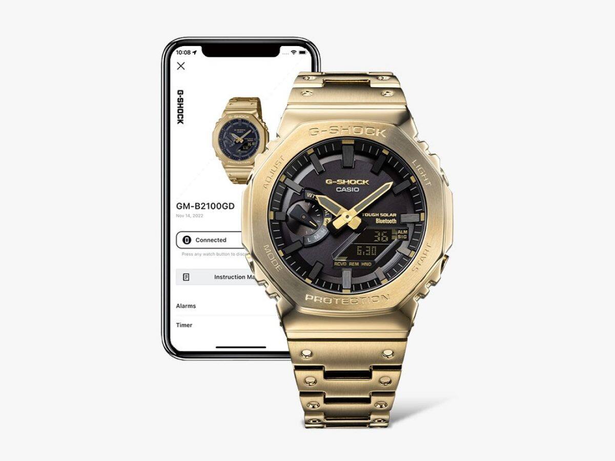 O relógio GM-B2100GD-9A ao lado de um smartphone que mostra a aplicação CASIO WATCHES, simbolizando o emparelhamento Bluetooth. 