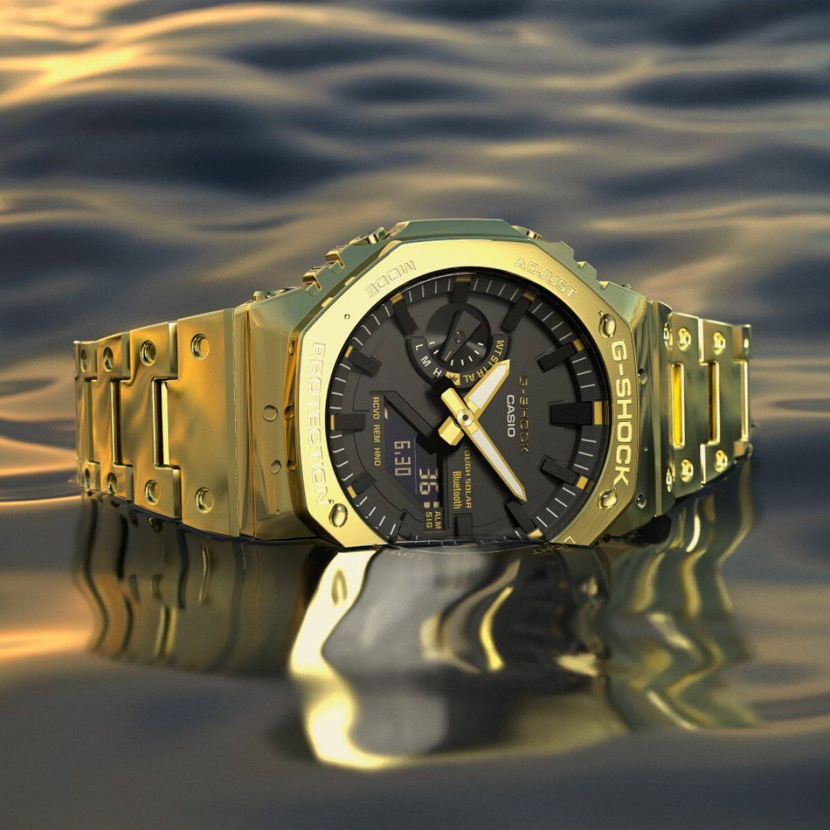 O G-SHOCK GM-B2100GD-9A colocado numa superfície semelhante à água