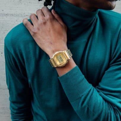 Metallic gold G-SHOCK GM5600YMG-9 watch with silicone watch band on a person’s wrist denoting style