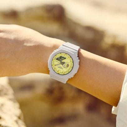 G-SHOCK GMA-S2100NC-4A digital-analog watch in tan with yellow watch face on a smaller wrist.