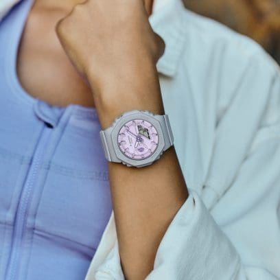 G-SHOCK GMA-S2100NC-8A digital-analog watch in grey with a light purple watch face on a smaller wrist.