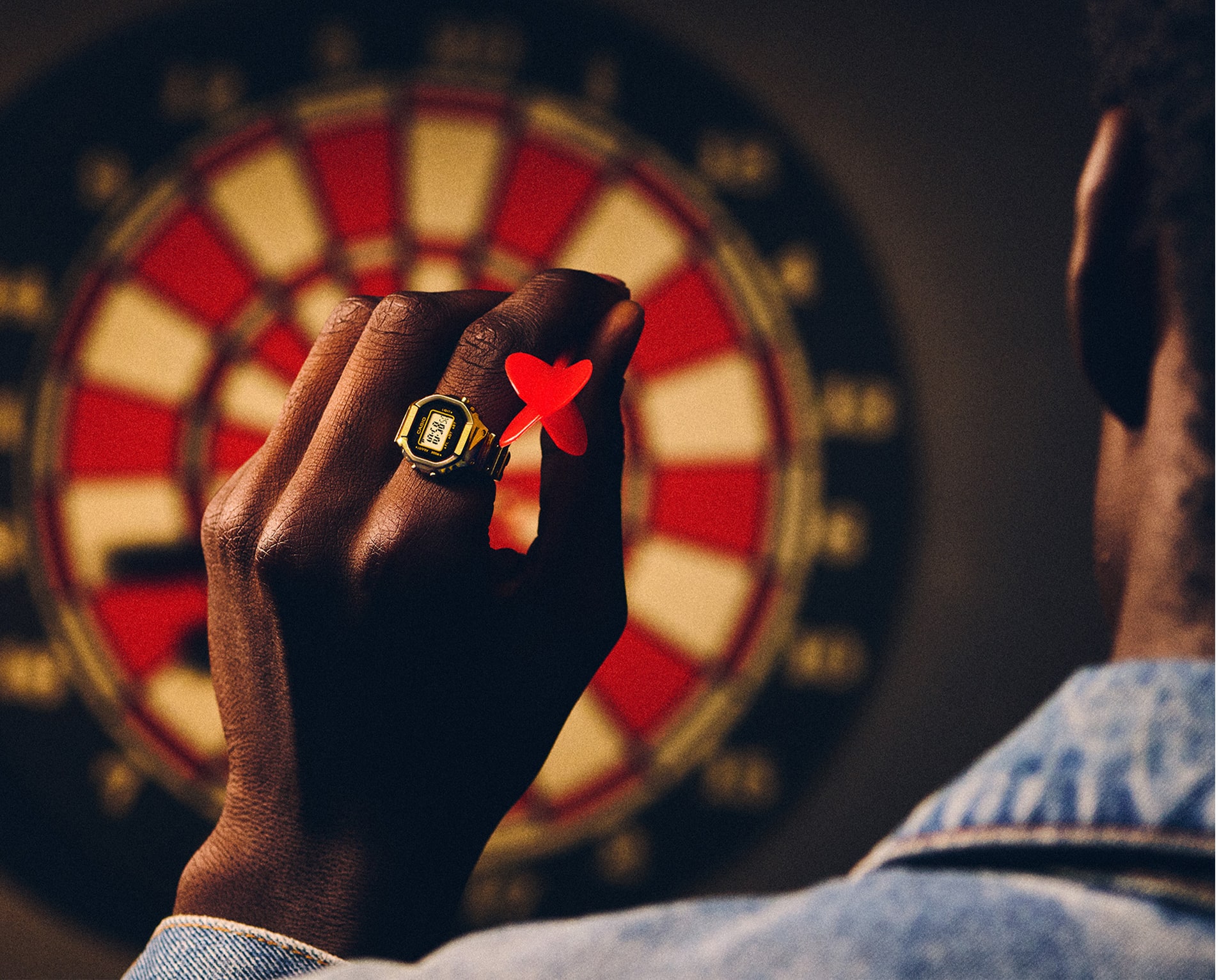 Foto eines Mannes, der CRW-001G an seinem Finger trägt und Dart spielt.