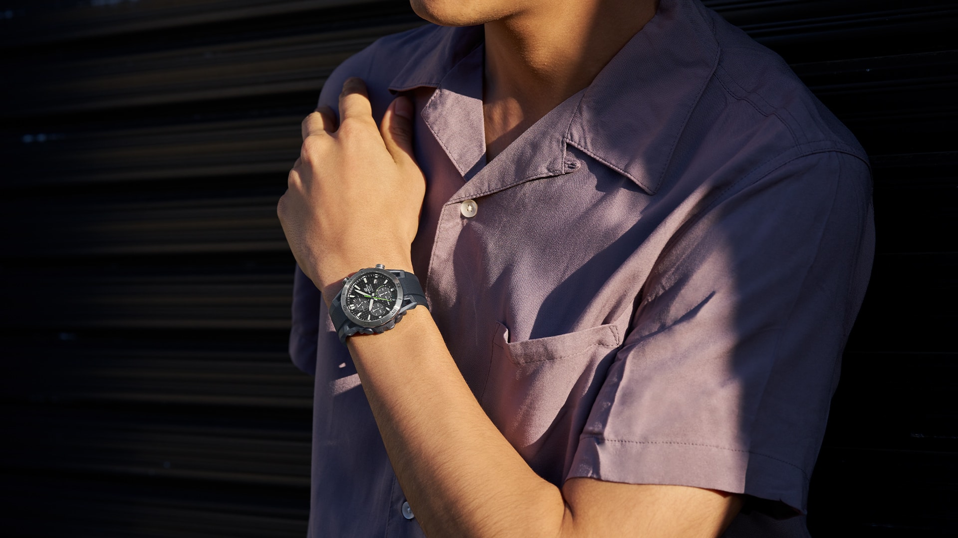 Une montre Casio Edifice au poignet d'un homme portant une chemise lilas.