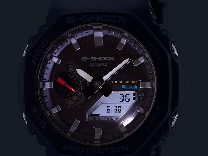 Das Display einer Casio G-Shock GA-B2100 Armbanduhr im Dunkeln mit beleuchtetem Zifferblatt
