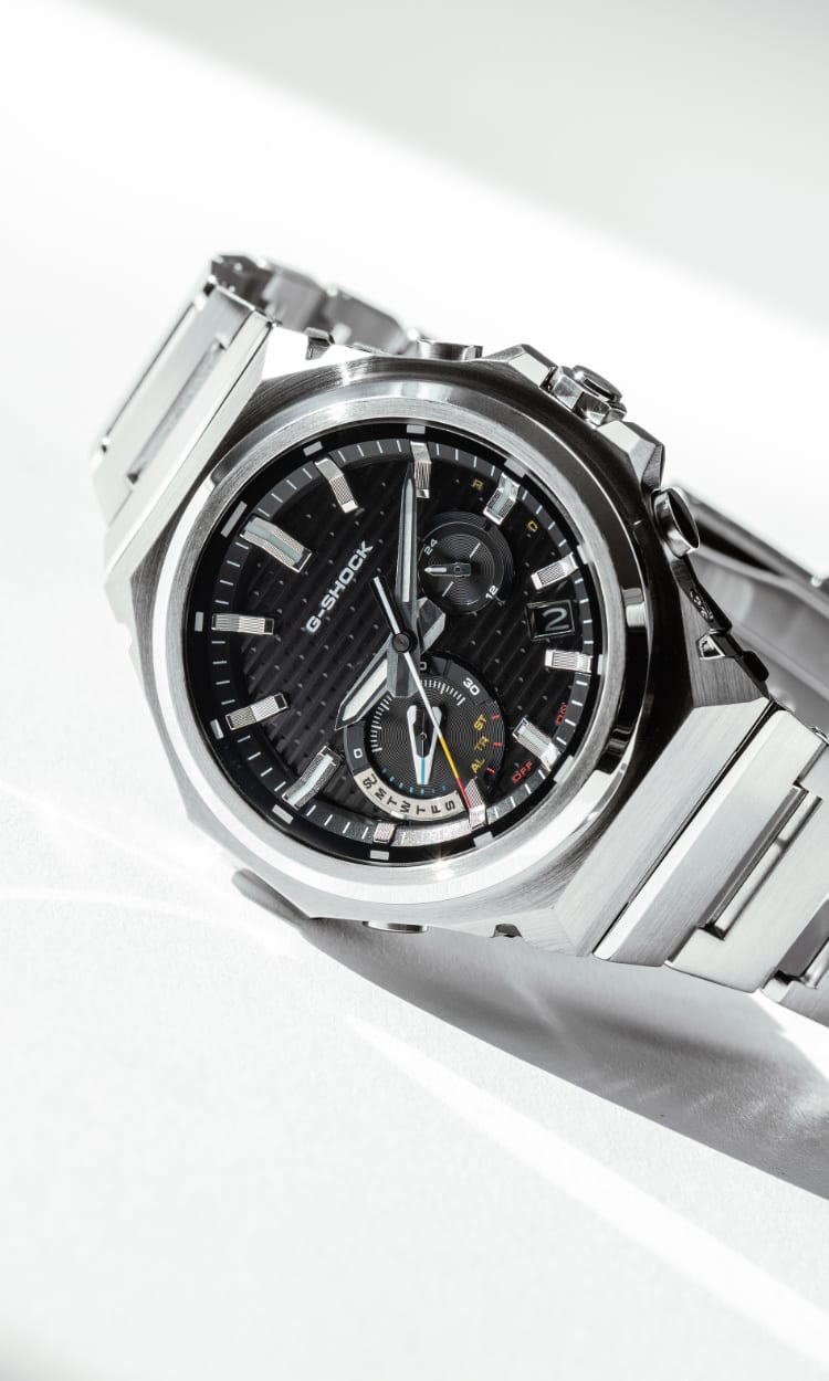 Nahaufnahme der silbernen Armbanduhr GST-B1000 mit schwarzem Zifferblatt von G-SHOCK auf einem weißen Tisch