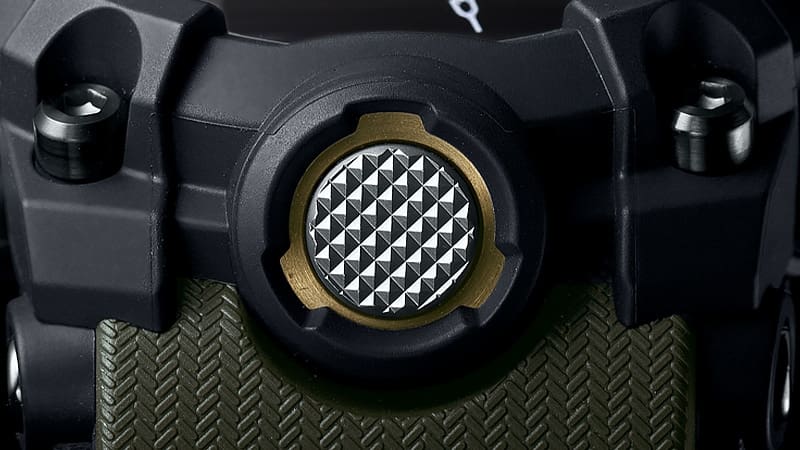 Detailsaufnahme des silberfarbenen Knopfes unten am Gehäuse (6-Uhr-Position)