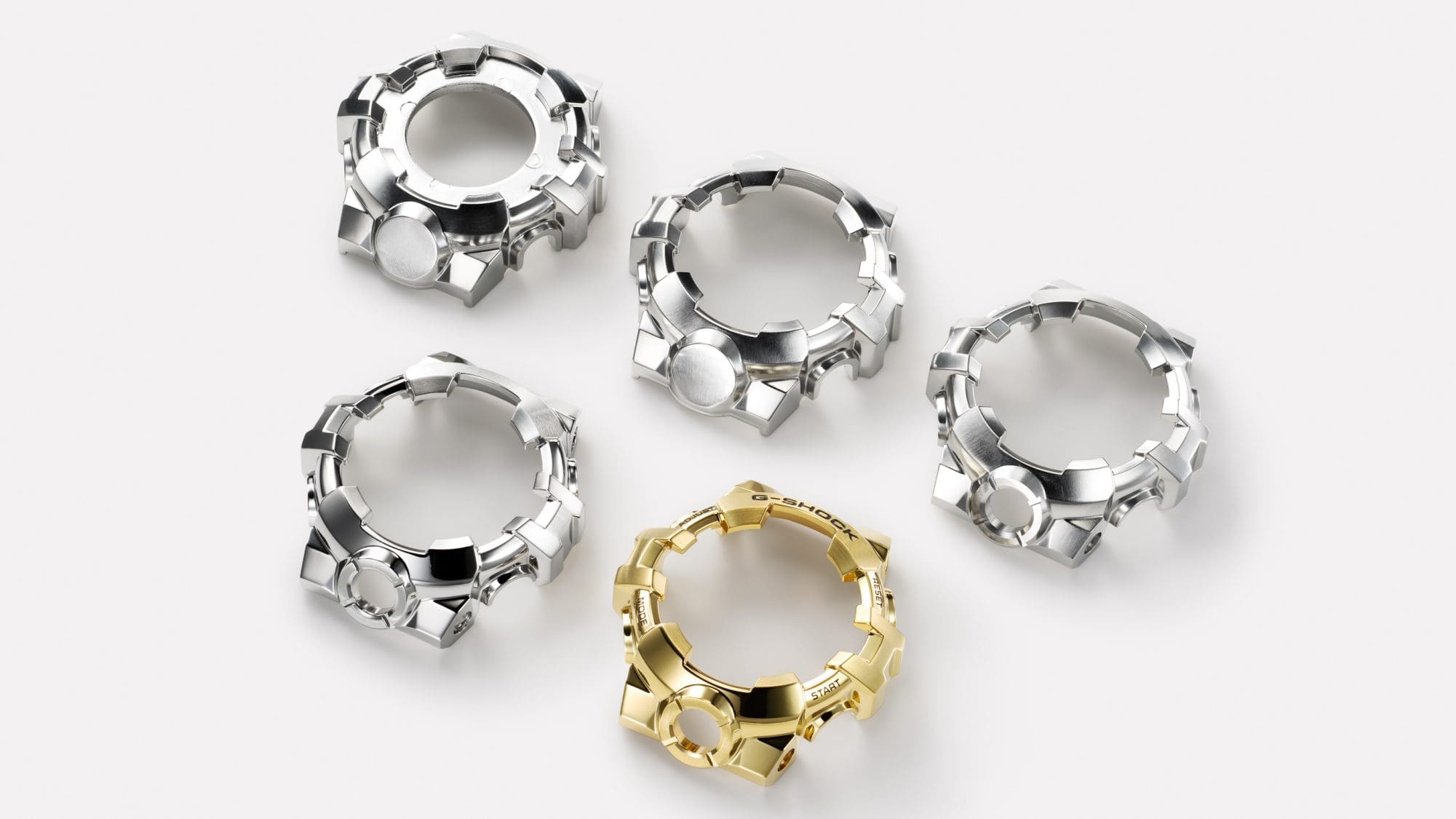 Five metal bezels, each differing from the others in detail; four are silver-coloured and one is gold-coloured