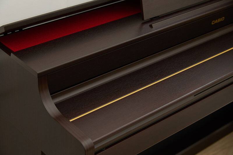Close-up of a brown CASIO AP-300 digital piano with the keyboard cover closed. 