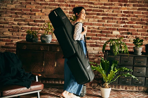 A young woman carries the black SC-800 keyboard bag over her shoulder