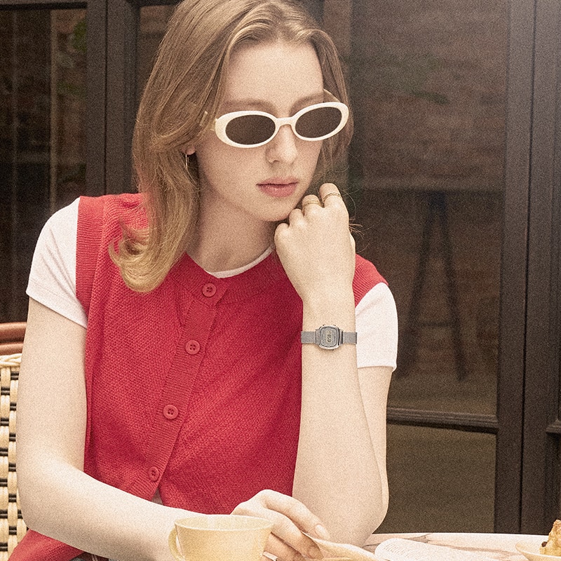 Photo of a woman wearing sunglasses and a watch.