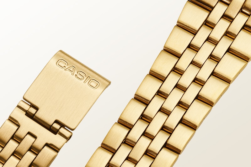 Photo of a gold watch with a metal band.