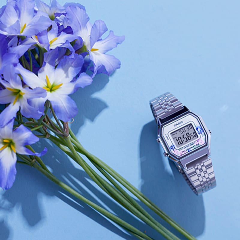 Image of a blue flowers and a watch with floral design on its face.