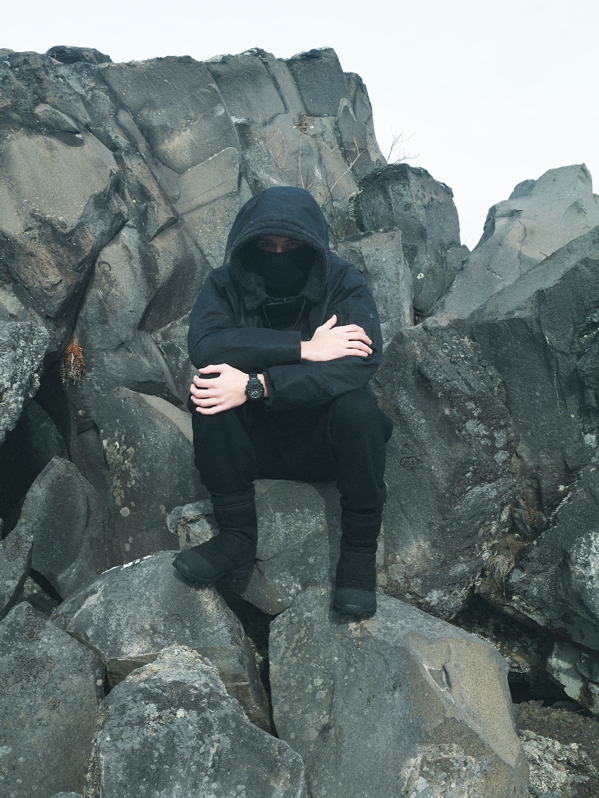 A photo of a man wearing the PRW-B1000WM-1 sitting on a rocky outcrop