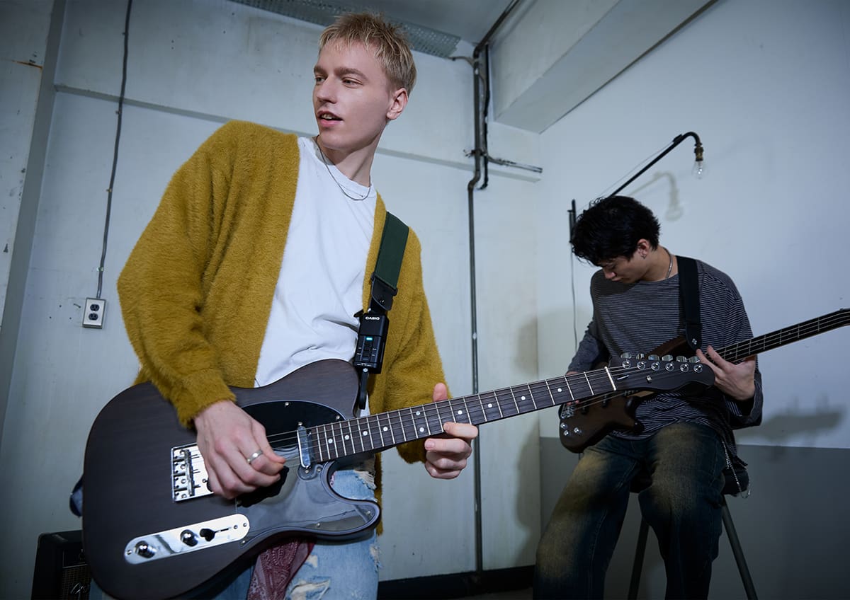 A photo of a guitarist wearing the DN-SE10 enjoying a jam session with a bassist