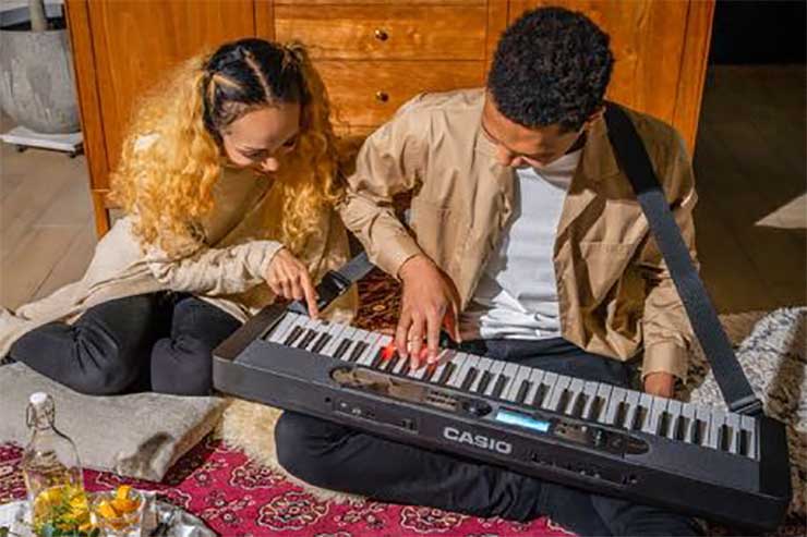 Casiotone LK-S450 with lighted keys strapped and being played by musician Casiotone LK-S450 with lighted keys strapped and being played by musician