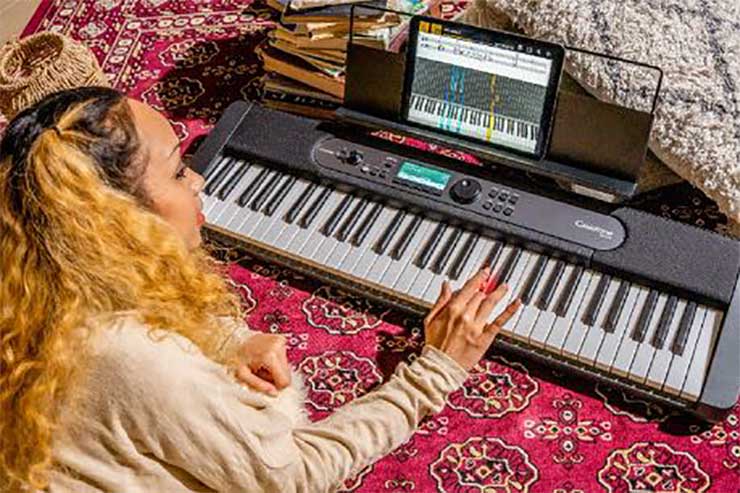 Casiotone LK-S450 with lighted keys being played by a woman following an ipad tutorial Casiotone LK-S450 with lighted keys being played by a woman following an ipad tutorial