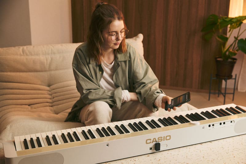 An image of a person connecting the piano and their smartphone.