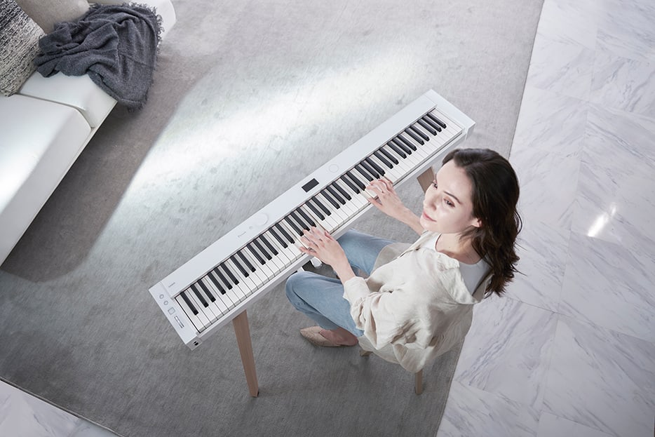 High angle perspective of white PX-S7000 being played in a white room 