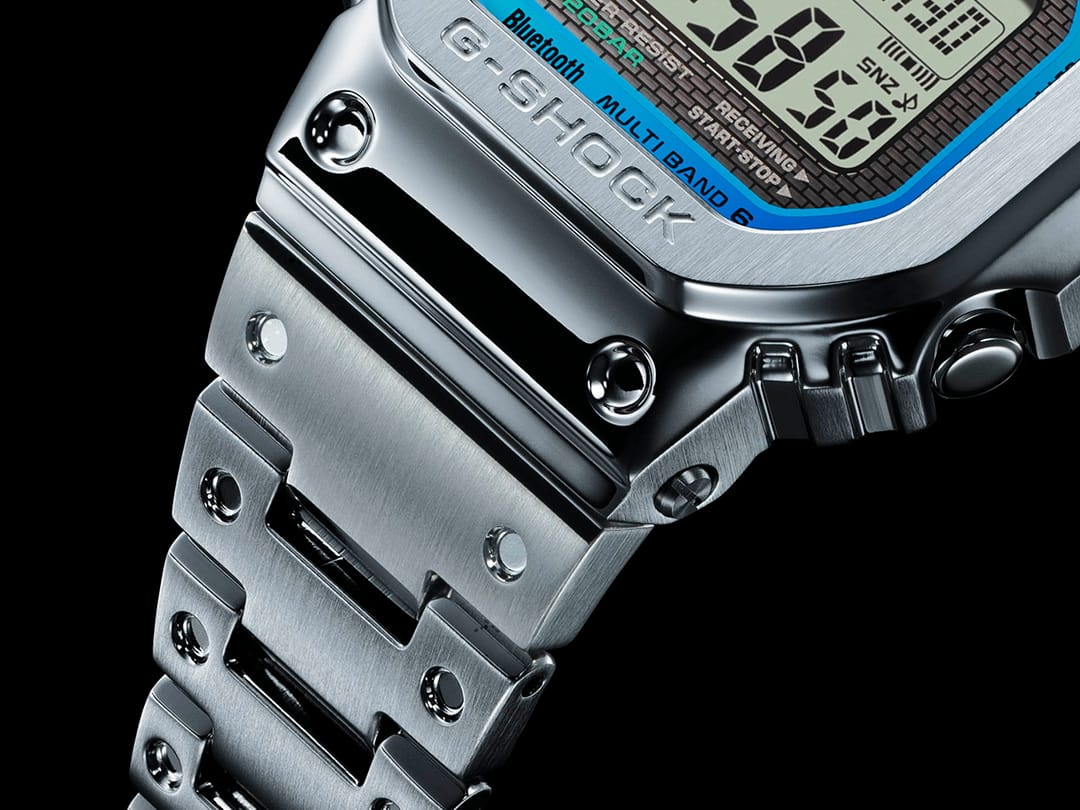 Transición de la correa de acero inoxidable a la caja de acero inoxidable de un reloj digital Casio G-Shock GMW-B5000PC-1 con superficies cuidadosamente renderizadas