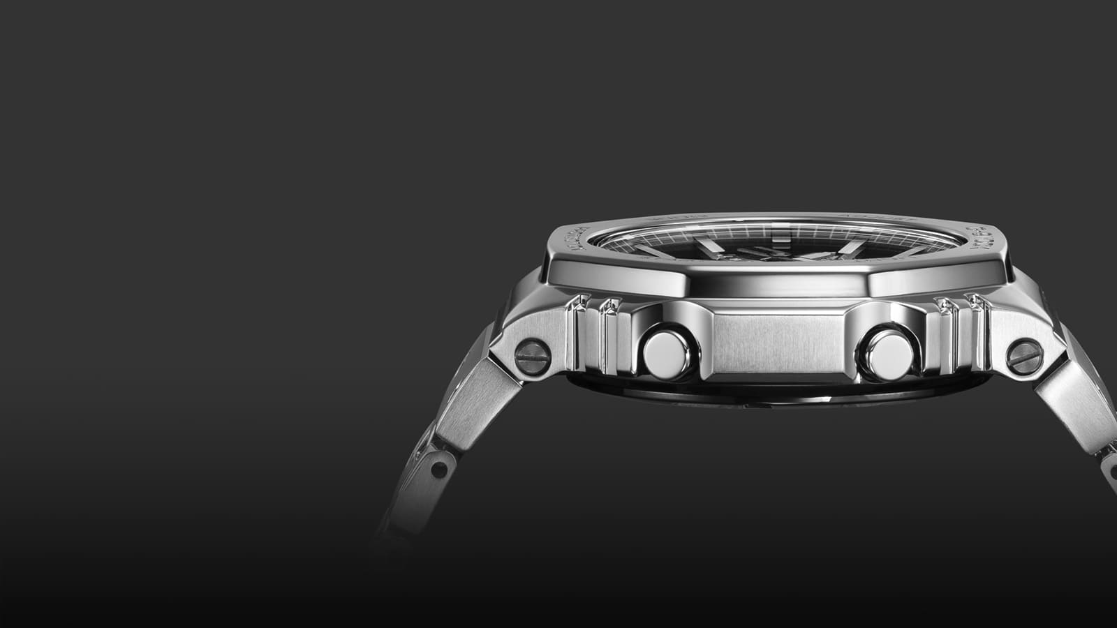 Vista lateral de la caja plana plateada del reloj Casio G-Shock GM-B2100D con sus botones y tornillos