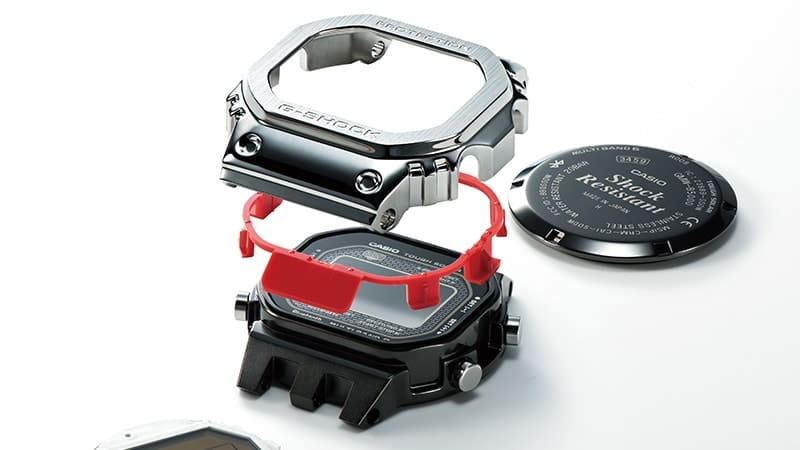 Componentes de la carcasa del reloj Casio G-Shock GMW-B5000 de metal macizo presentados individualmente uno encima del otro
