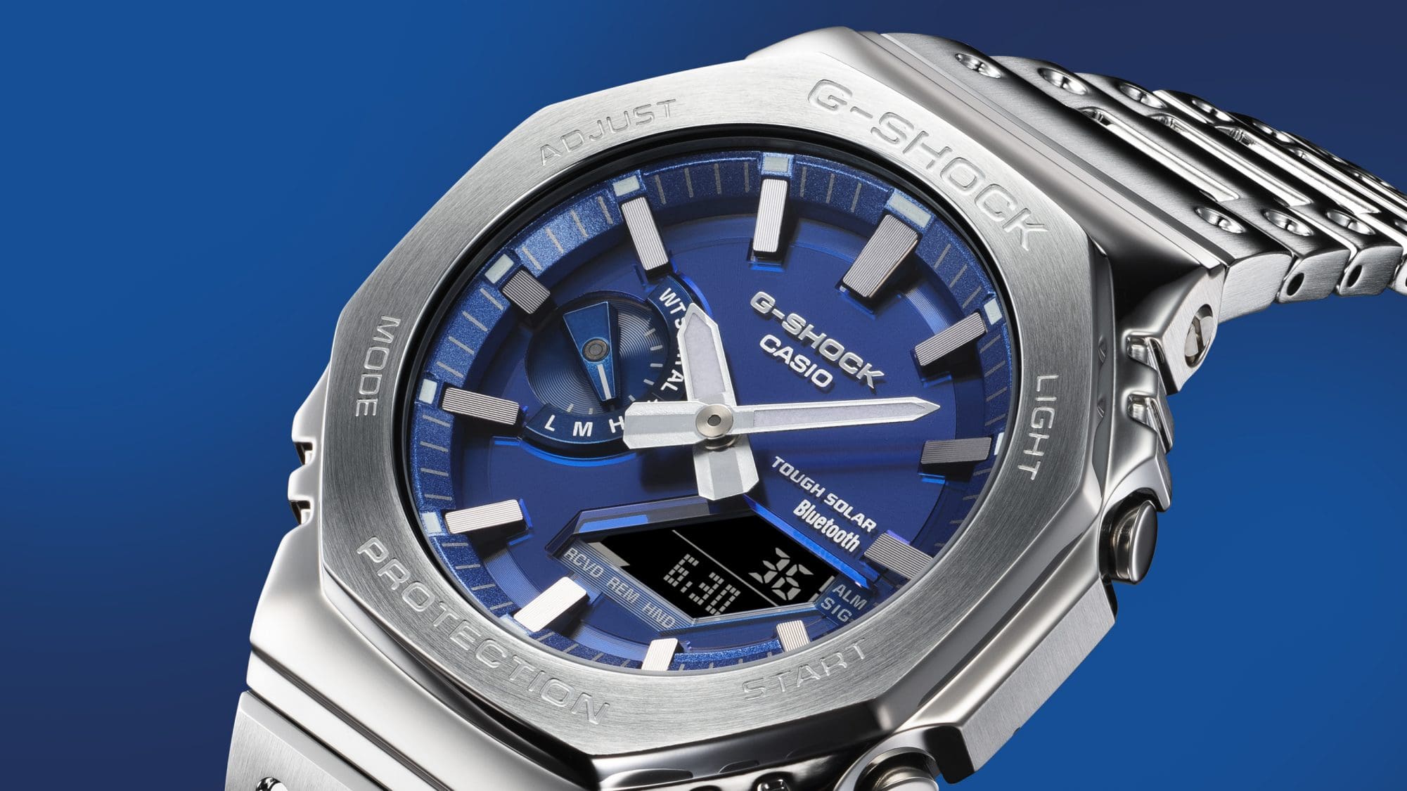 Vista desde arriba oblicua de la pantalla y la carcasa del reloj Casio G-Shock GM-B2100AD plateado con esfera azul