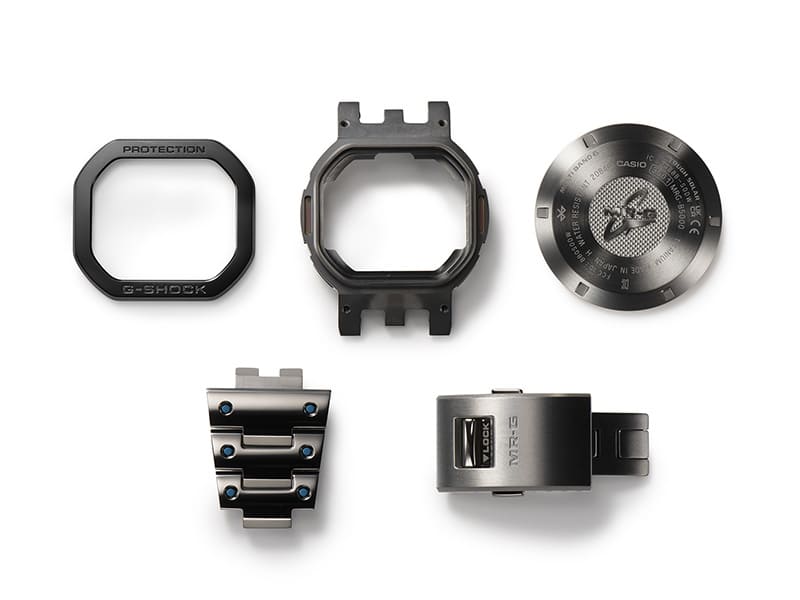 Los componentes del reloj de pulsera Casio G-Shock MRG-B5000BA, que consta de cobalto y DAT55G: bisel, parte posterior de la carcasa, correa y cierre de la correa