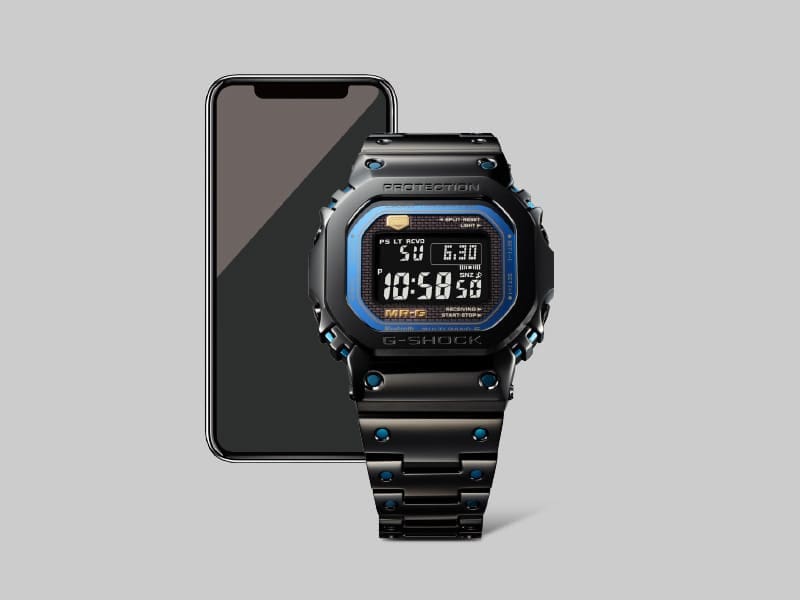 El reloj G-Shock MRG-B5000BA-1 Bluetooth® delante de un smartphone