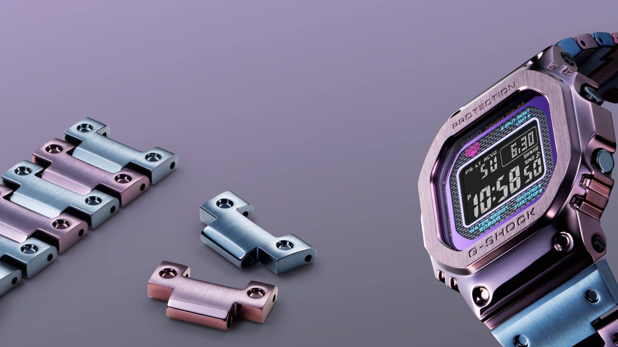 El reloj Casio G-Shock GMW-B5000PB-6 de metal en tonos violeta y azul junto a un trozo de su correa y a eslabones sueltos de la misma.