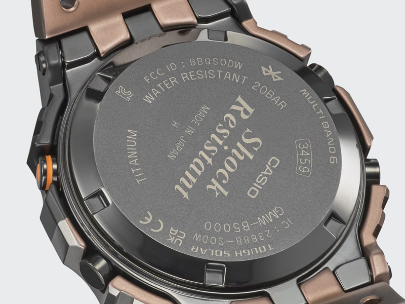 La parte trasera negra de la caja de un GMW-B5000TVB-1 con las siguientes inscripciones, entre otras: Casio, Shock Resistant, Made in Japan, Titanium, Water Resistant 20Bar, Multi Band 6, Tough Solar