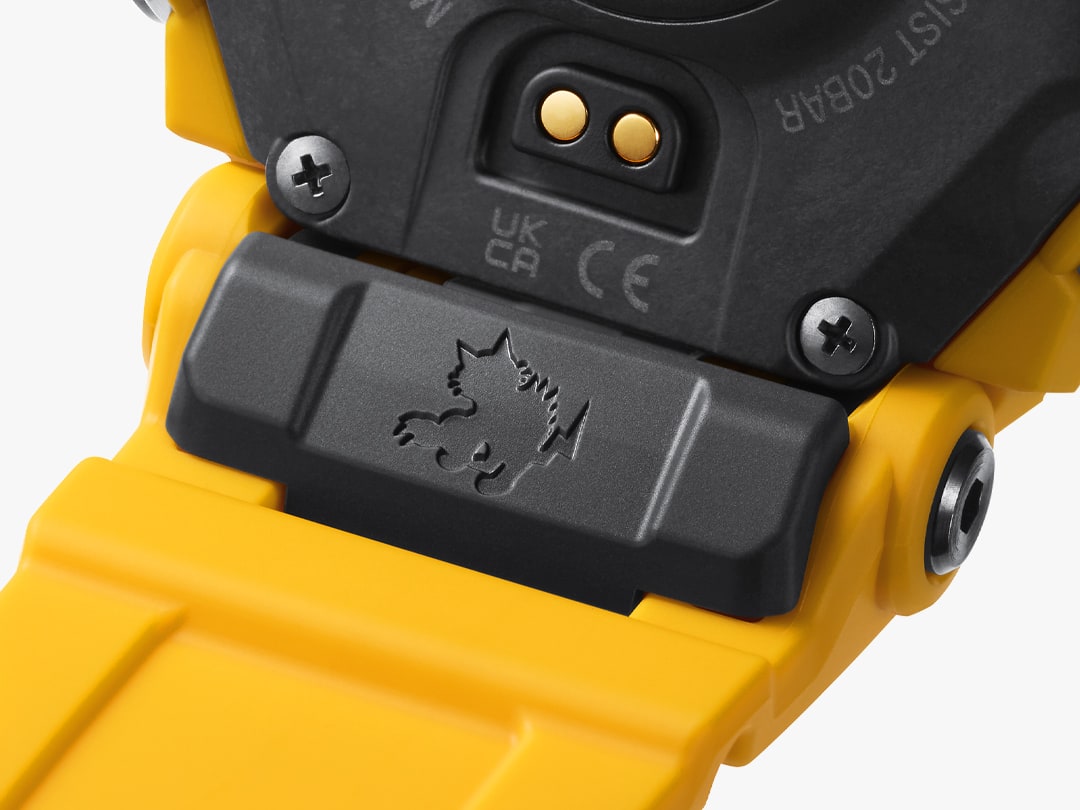 Primer plano del punto de encuentro entre la correa amarilla y la carcasa negra con vista al grabado de un gato montés de Rangeman en el reverso del reloj de pulsera